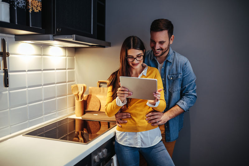 couple in kitchen on tablet